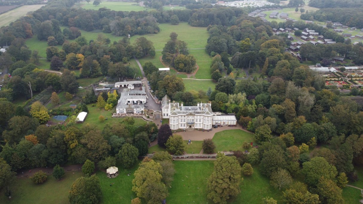 Aerial view of a large estate surrounded by greenery and trees.
